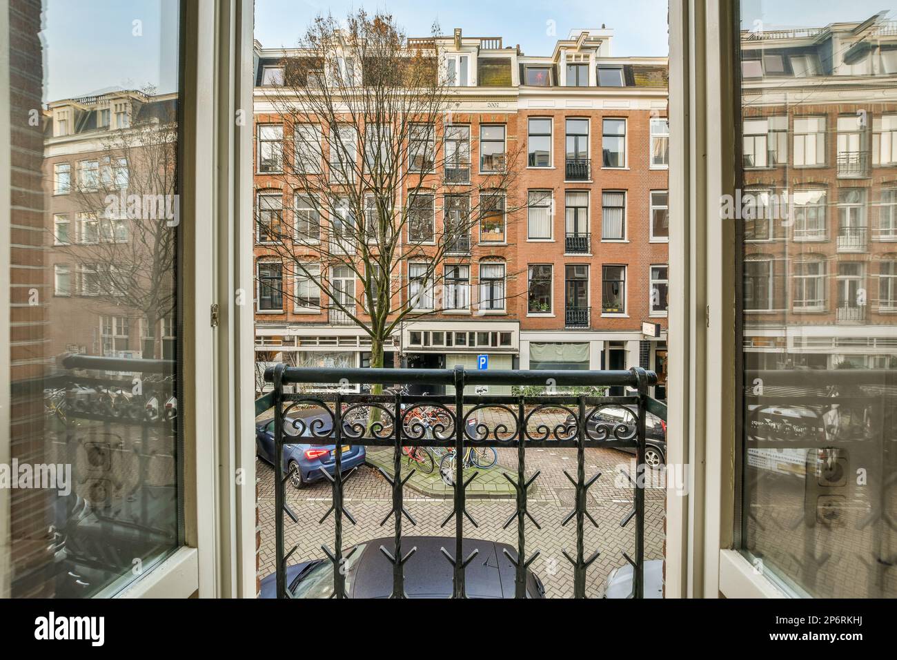 Amsterdam, pays-Bas - 10 avril 2021 : vue d'une fenêtre ouverte dans un bâtiment avec des voitures garées dans la rue à l'extérieur et des bâtiments visibles derrière Banque D'Images