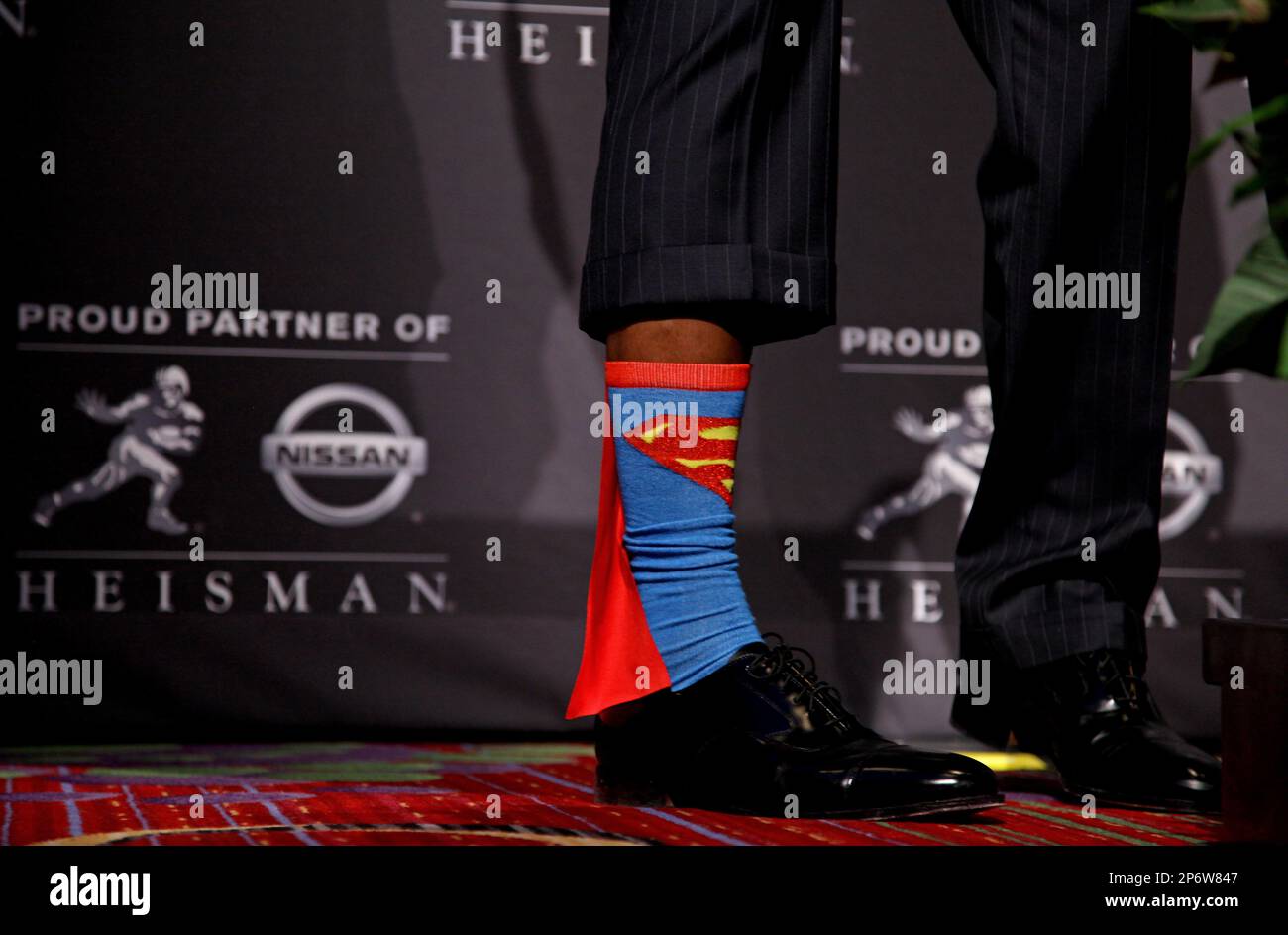 Heisman Trophy winner Robert Griffin III, of Baylor, shows off his Superman socks during a news conference after the ceremony, Saturday, Dec. 10, 2011, in New York. The junior quarterback known as RG3 became the first Heisman winner from Baylor. (AP Photo/Craig Ruttle) Banque D'Images