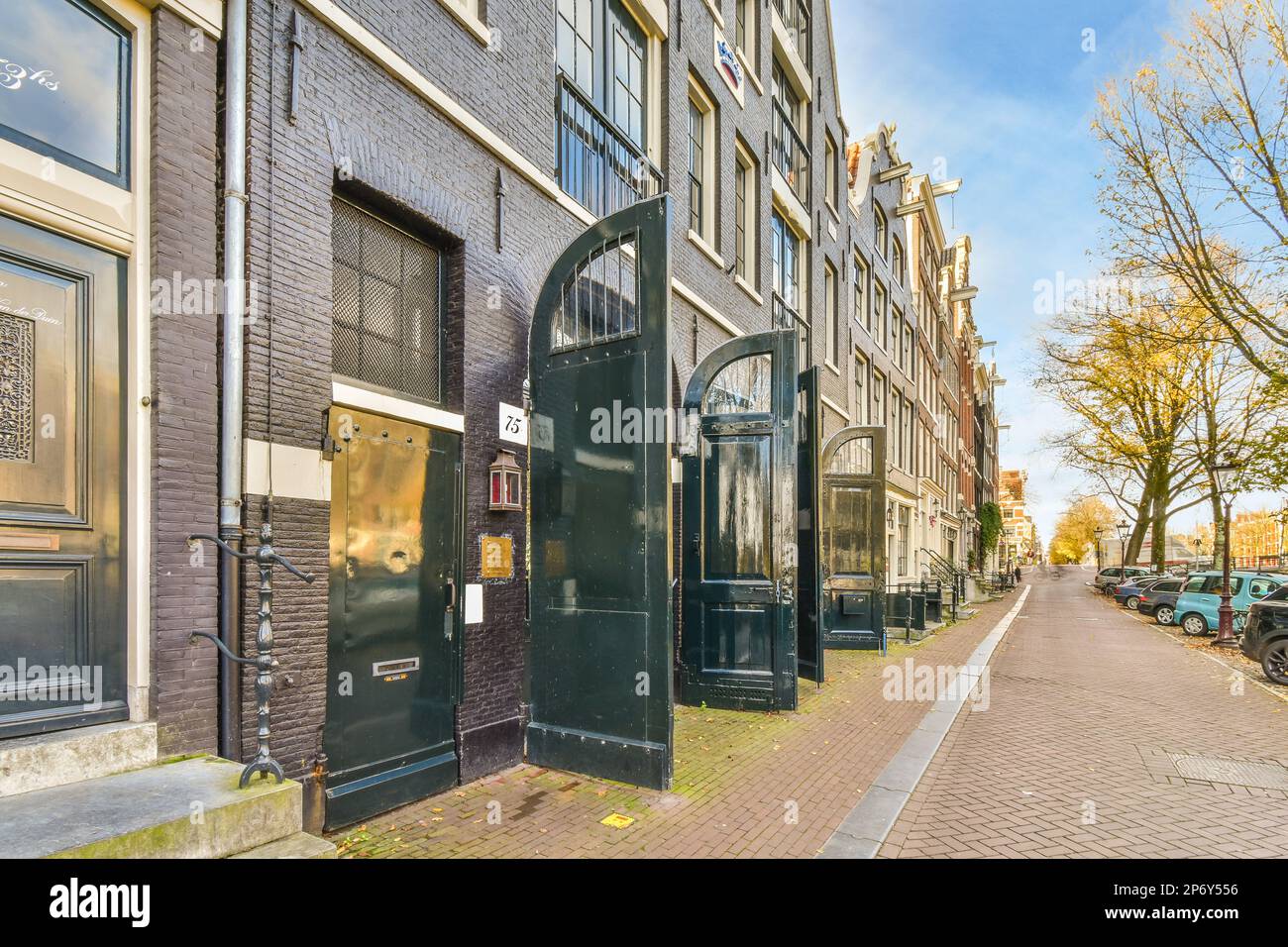 Amsterdam, pays-Bas - 10 avril 2021 : rue de la ville avec des voitures garées sur le côté et des bâtiments à l'arrière-sol, le long des ruelles Banque D'Images