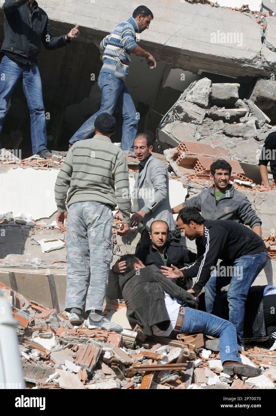 People try to save people trapped under debris in Tabanli village near the city of Van after a powerful earthquake struck eastern Turkey Sunday Oct. 23, 2011, collapsing some buildings and causing a number of deaths, an official said. ( AP Photo/ Abdurrahman Antakyali, Aatolia) TURKEY OUT Banque D'Images