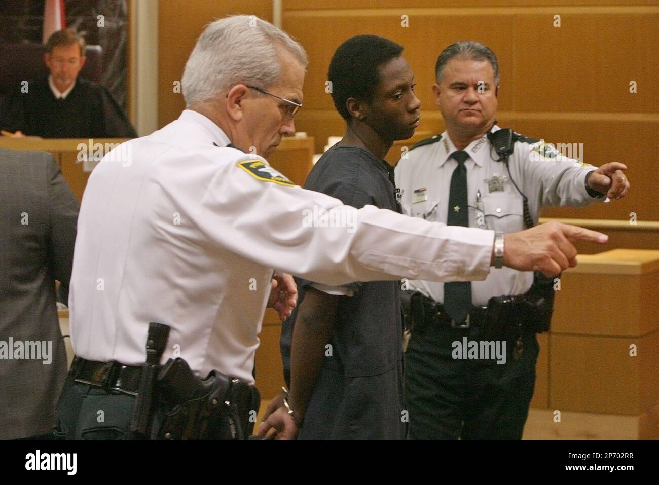 Nicholas Lindsey, 16, center, accused of killing St. Petersburg Police Officer David S. Crawford, is lead out of court Friday, Oct. 21, 2011 by bailiffs after an appearance in front of Circuit Court Judge Thane V. Covert, left, at the Pinellas County Criminal Courts Complex in Largo, Fla. (AP Photo/Scott Keeler, Pool) Banque D'Images