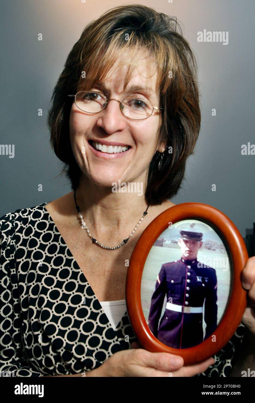 In this Oct. 6, 2011 photo, Debbie Juenette holds a photo of her brother, Warren McElhanon, in White Post, Va. When William "Cody" Jeunette sat down with his family for lunch on Sept. 9 after graduating from boot camp at the U.S. Marine Corps training facility at Parris Island, S.C., his aunt Shelly McElhanon handed him a wooden box with the Marine Corps insignia on top. Inside was a small rectangular piece of metal, a single "dog tag" - an identification disc from another Marine, Cody's uncle Warren Shelby McElhanon, who was killed by a bomb in Vietnam in March 1966. (AP Photo/The Winchester  Banque D'Images