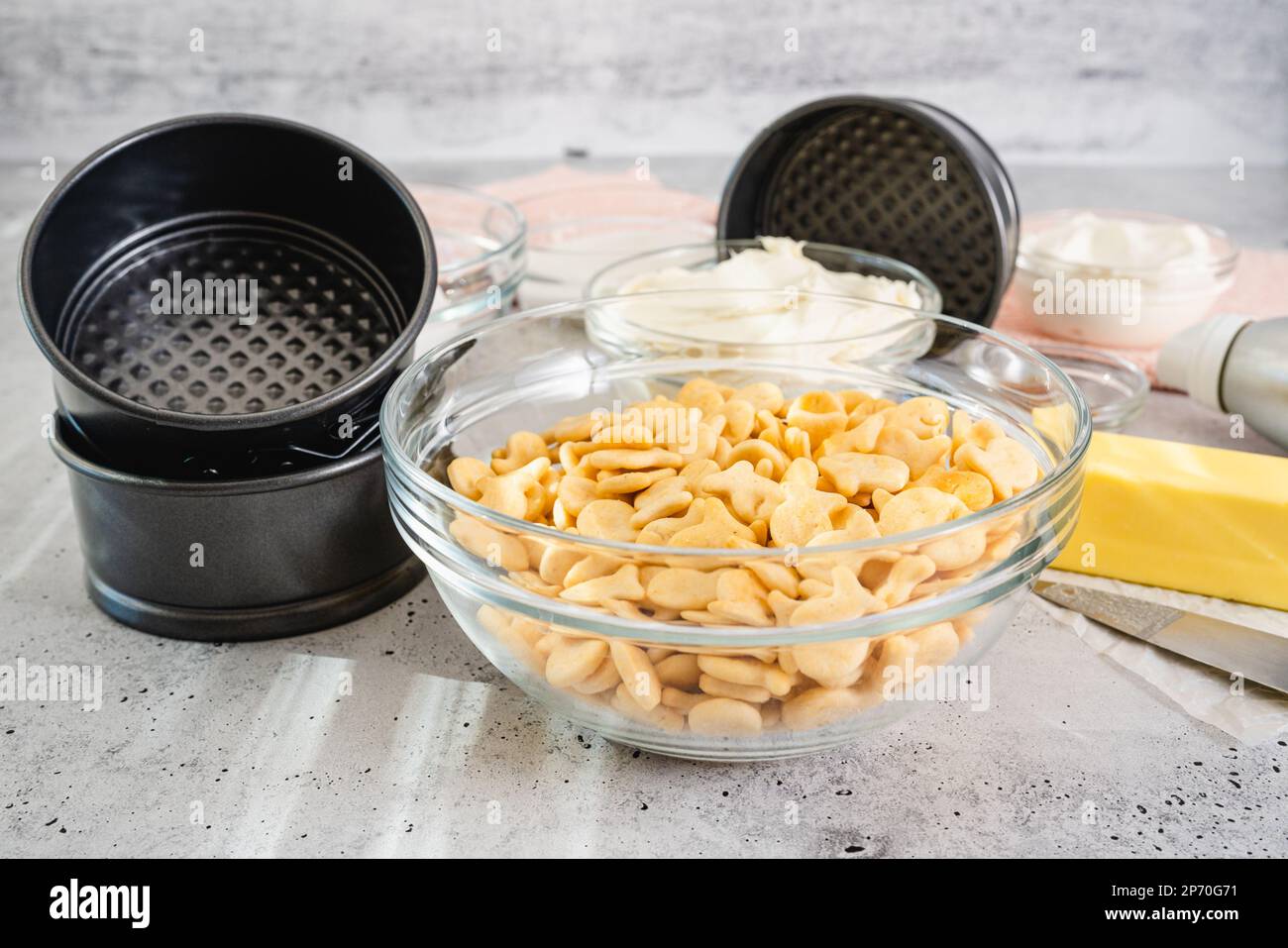 Recette de cheesecake. Trois mini moules à gâteau ronds (moule, moule), et des ingrédients frais pour la recette du cheesecake gros plan sur la table de cuisine, plat Banque D'Images