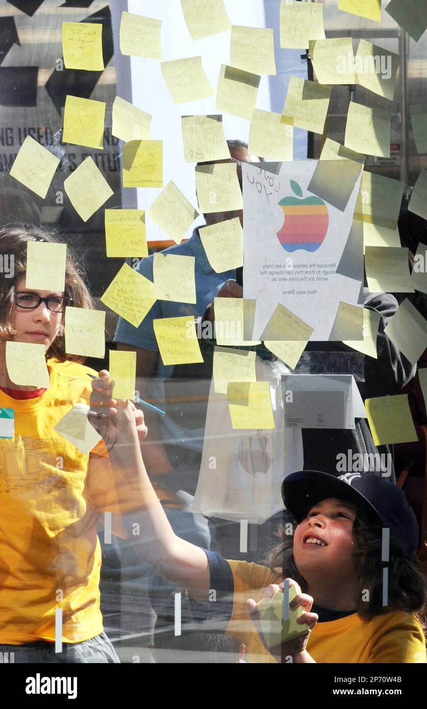 Children write a tribute message to Steve Jobs, former CEO and co- founder of the Apple in front of a Apple Store in New York on Oct. 6, 2011. Jobs admires and fans gathered at Apple stores around the world to express their grief at his death. He passed away at age of 56. ( The Yomiuri Shimbun via AP Images )( The Yomiuri Shimbun via AP Images ) Banque D'Images