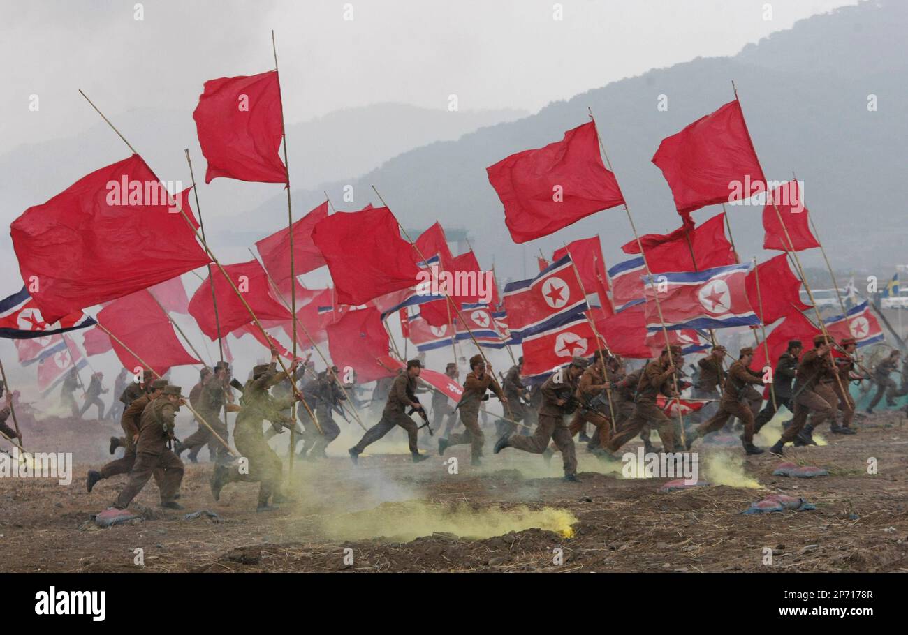 South Korean army soldiers dressed like North Korean soldiers re-enact the Battle of the Naktong Bulge near the Waegwan railway bridge in Waegwan, South Korea, Thursday, Sept. 29, 2011. The South Korean soldiers re-enacted the 1950 battle, one of the key engagements as part of events to mark the 61th anniversary of the Korean War. (AP Photo/Ahn Young-joon) Banque D'Images