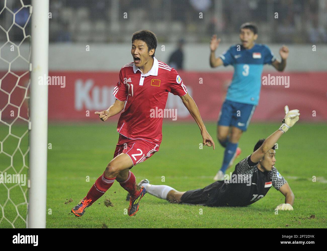 China's Yu Hai (L) celebrates for a goal as Singapore's goalkeeper Lionel Lewis (R) reacts during a Group A football match in the 2014 World Cup third-round qualifier in Kunming in southwest China's Yunnan province on Friday, Sept. 2, 2011. China beat Singapore 2-1.(Photo By Liu Ranyang/Color China Photo/AP Images) Banque D'Images