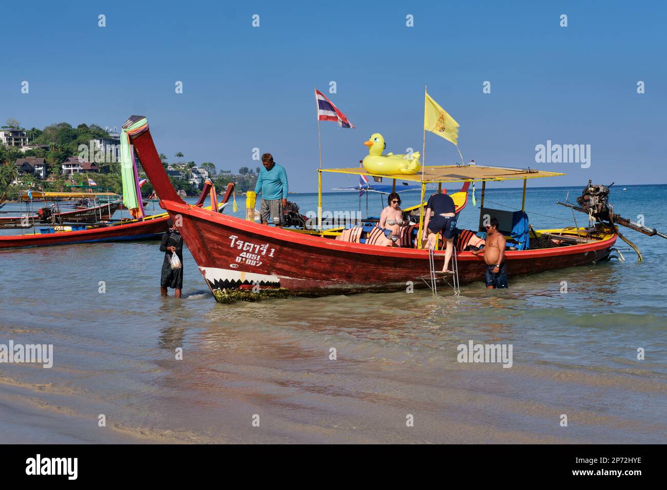 Un touriste monte à bord d'un bateau à longue queue à Kamala Beach, Phuket, Thaïlande, prêt pour une excursion en bateau Banque D'Images