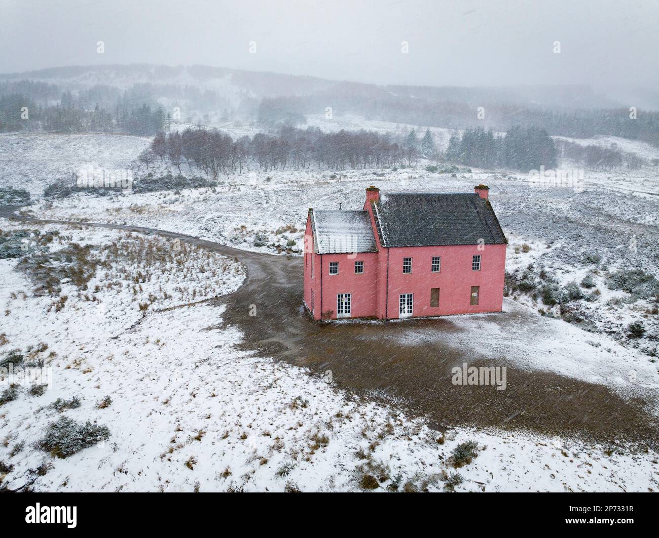 Vues aériennes de Culzie Lodge également connu sous le nom de Maison rose dans la neige sur les rives du Loch Glass à Pâques Ross, en Écosse Banque D'Images