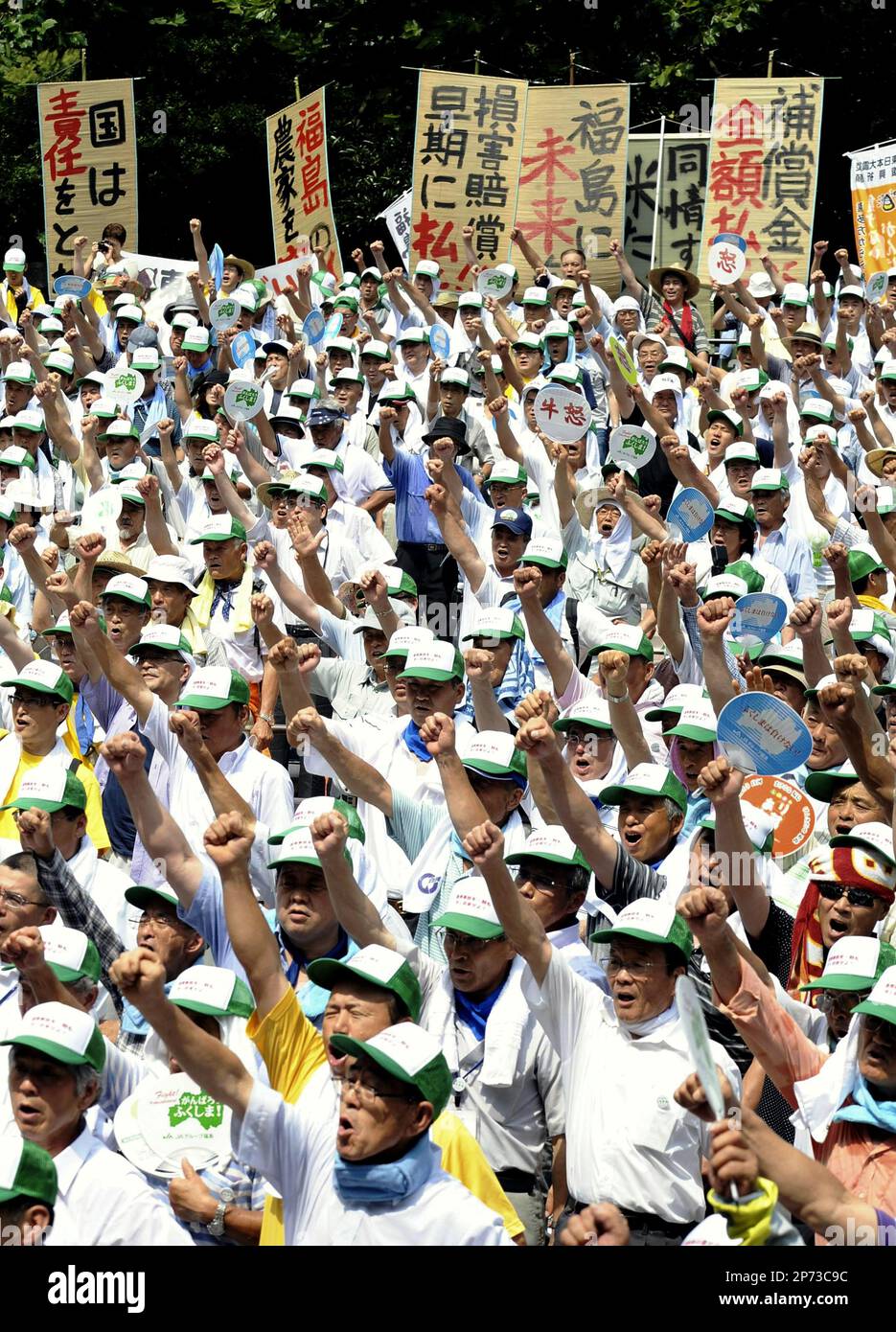 Farmers and fishermen from Fukushima Prefecture protest in Tokyo's Hibiya Park in Chiyoda Ward, calling for early compensation over the crisis at the Fukushima No. 1 nuclear power plan, Aug 12, 2011. The participants of the rally, carrying protest banners, marched to the nearby head office of plant operator Tokyo Electirc Power Co. ( The Yomiuri Shimbun via AP Images ) Banque D'Images