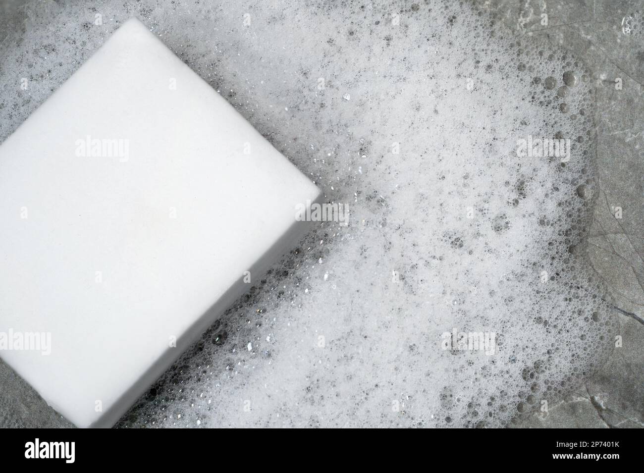 Gros plan photo éponge blanche et mousse ou bulles de savon comme symbole d'hygiène et d'hygiène. Service de nettoyage et de lavage. Banque D'Images