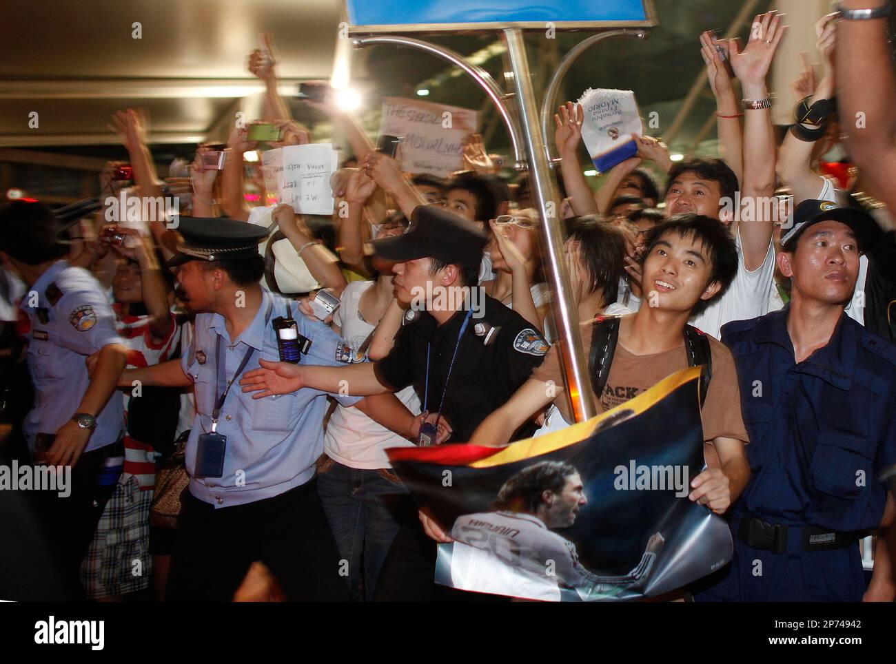 Policemen keep order as Chinese fans go wild upon Spain football club Real Madrid's arrival at the Baiyun international airport in Guangzhou in south China's Guangdong province on Sunday, July 31, 2011.Real Madrid will play a friendly match with Guangzhou Evergrande of the Chinese super league in Guangzhou on Aug. 3.(Photo By Fang Yingzhong/Color China Photo/AP Images) Banque D'Images