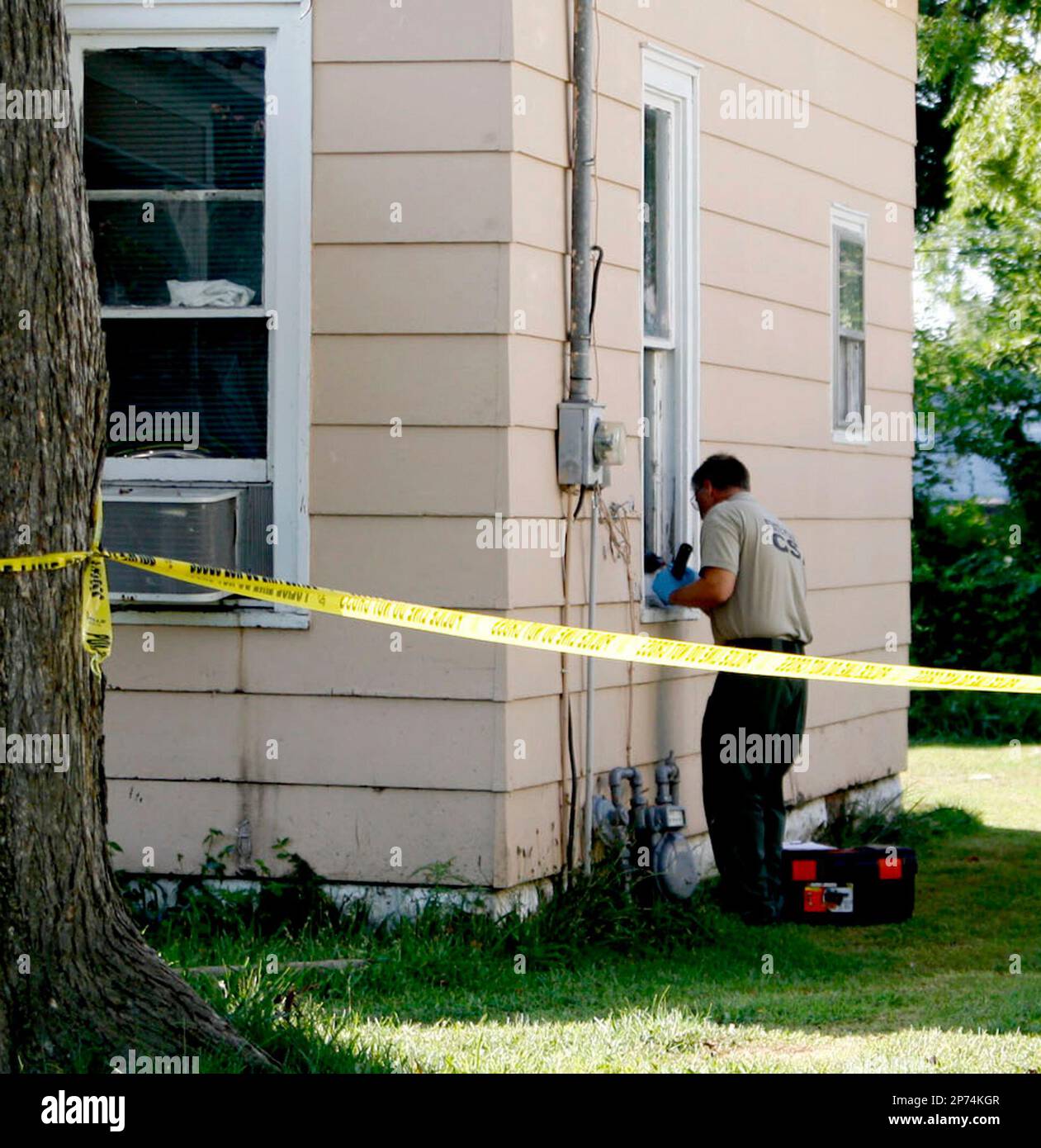 In this photo taken Tuesday, July 19, 2011, a crime scene technician with the Illinois State Police is seen outside a house in West Frankfort, Ill, where the body of 8-year-old Alexus Smothers was found in the crawl space after police came to the home responding to a report of a missing child. The girl's mother, Mary Jophlin, 28, was charged Tuesday with concealment of a death. (AP Photo/The Southern Illinoisan, Becky Malkovich) Banque D'Images