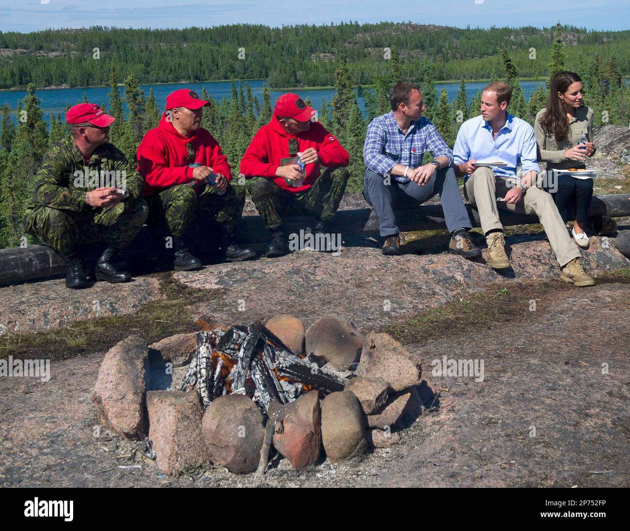 Prince William and wife Kate, the Duke and Duchess of Cambridge rest and have some arctic char with Defense Minister Peter McKay along with Canadian Rangers at Lake Blatchford, Canada, lodge on Tuesday, July 5, 2011. (AP Photo/The Canadian Press, Nathan Denette) Banque D'Images
