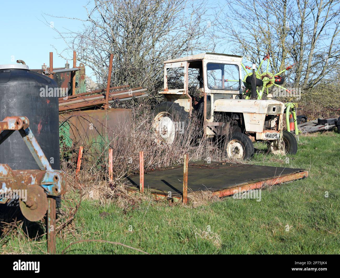 un tracteur dans le coin d'un champ, maintenant désutilisé et rouillé en panne Banque D'Images