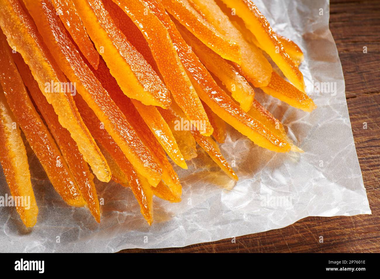Des peaux d'orange confites sur du papier de cuisson froissé Banque D'Images