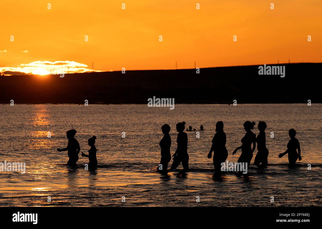 Des centaines de nageurs prennent un bain de soleil au Firth of Forth à Portobello Beach, Édimbourg, pour la Journée internationale de la femme. L'argent recueilli au cours de l'événement doit être donné à l'organisme de bienfaisance Women's Aid et cette année, c'est le 50th anniversaire de la succursale d'Édimbourg. Date de la photo: Mercredi 8 mars 2023. Banque D'Images