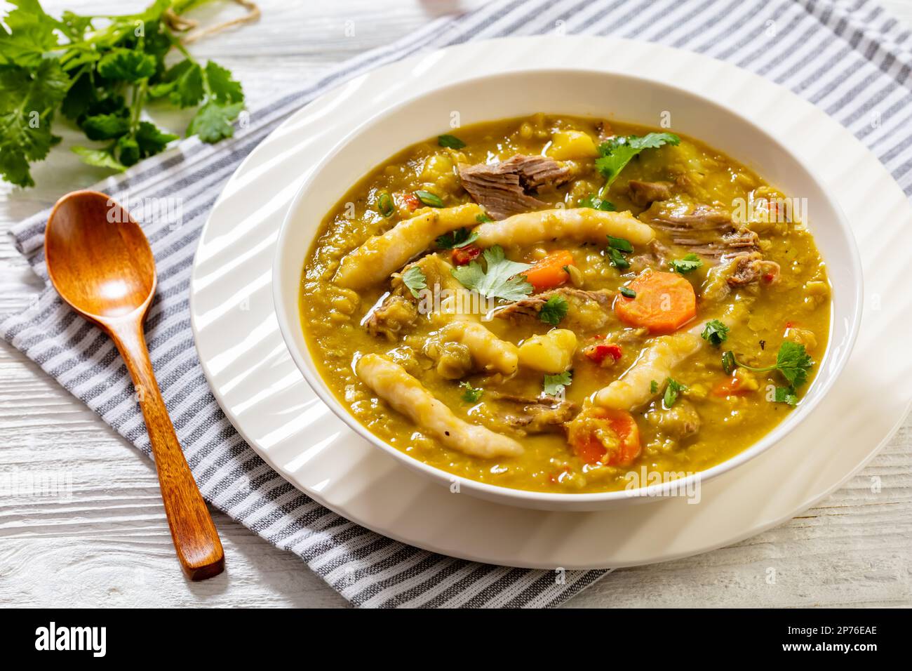 petits pois, soupe de petits pois avec boulettes, légumes et bœuf dans un bol blanc sur table blanche, cuisine jamaïcaine Banque D'Images