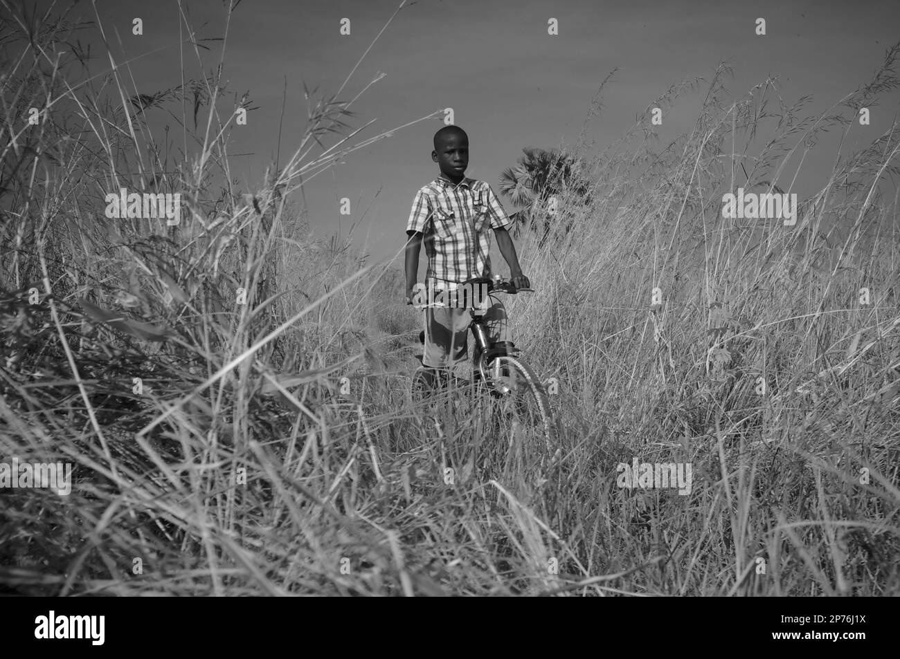 Un garçon africain à vélo dans le parc national de Pendjari Banque D'Images