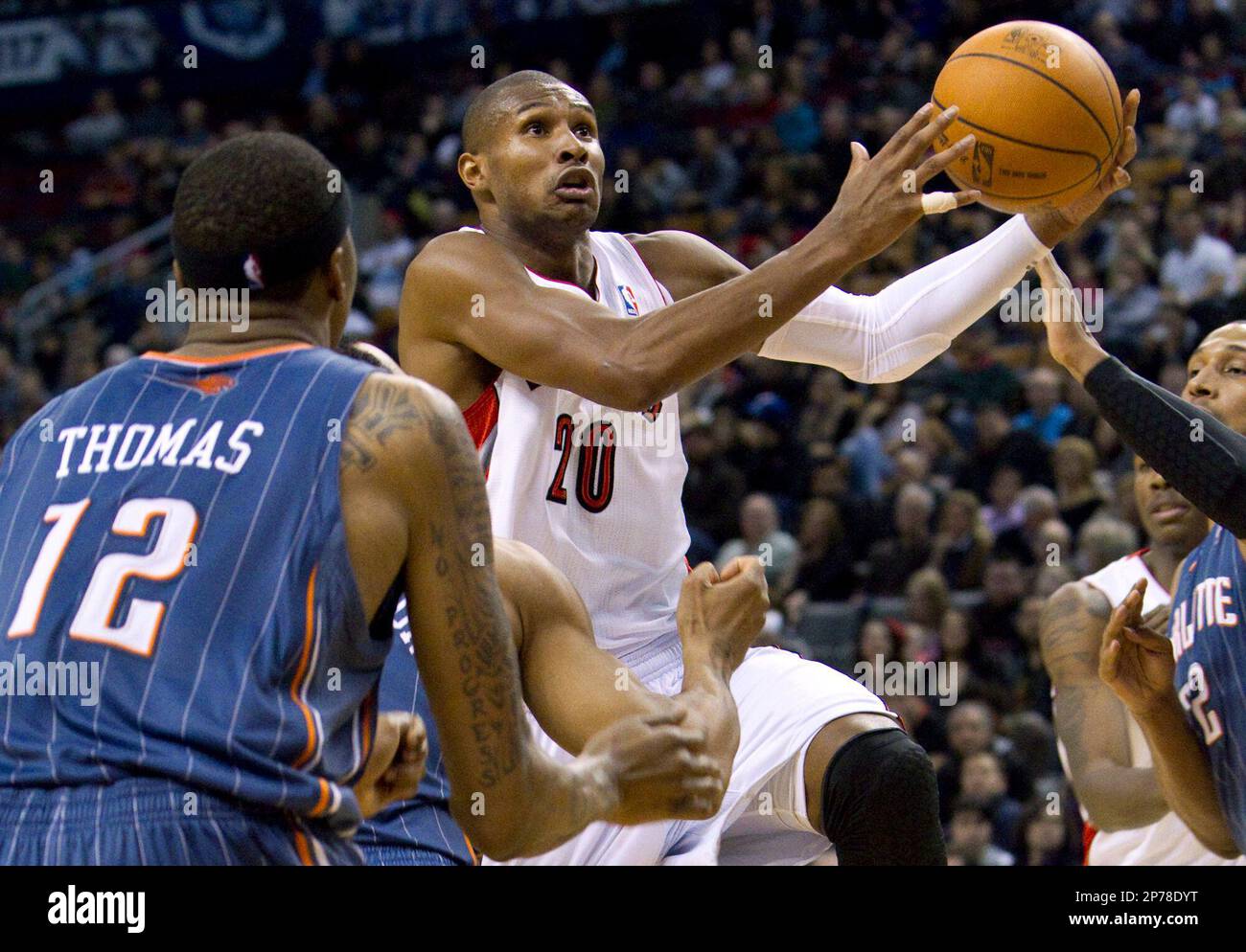 Toronto Raptors' Leandro Barbosa, center, scores past Charlotte Bobcats' Tyrus Thomas during the second half of an NBA basketball game in Toronto, Sunday, March 13, 2011. The Raptors lost to the Bobcats 90-95. (AP Photo/The Canadian Press, Darren Calabrese) Banque D'Images