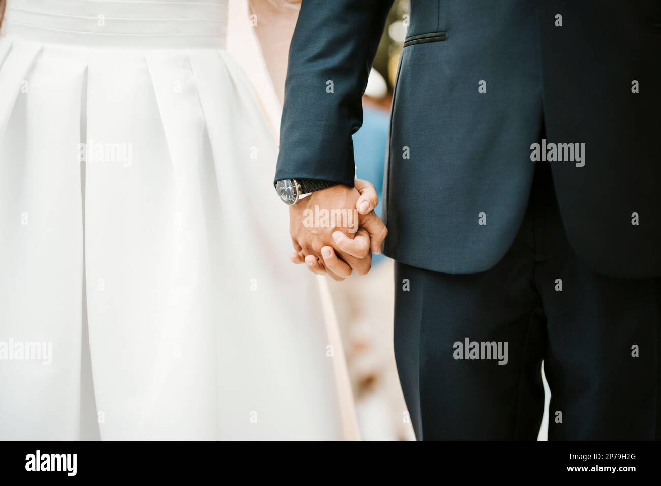 Mariée et marié tenant leurs mains pendant la cérémonie de mariage - concept d'amour Banque D'Images