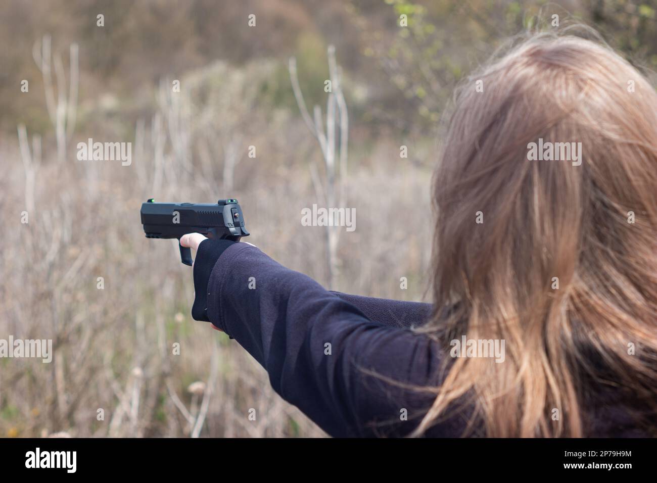 Les jeunes femmes bras et mains visant une arme de poing dans l'entraînement d'auto-défense cible pratique méconnaissable. Banque D'Images