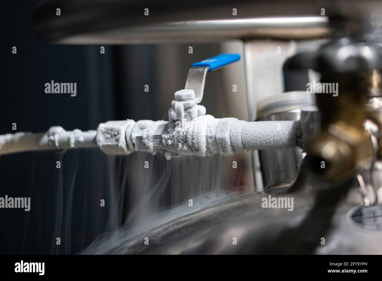 Robinet et levier gelés à l'azote liquide. Fumée de condensation blanche flottante visible provenant d'un gros plan isolé du réservoir sous pression. Banque D'Images