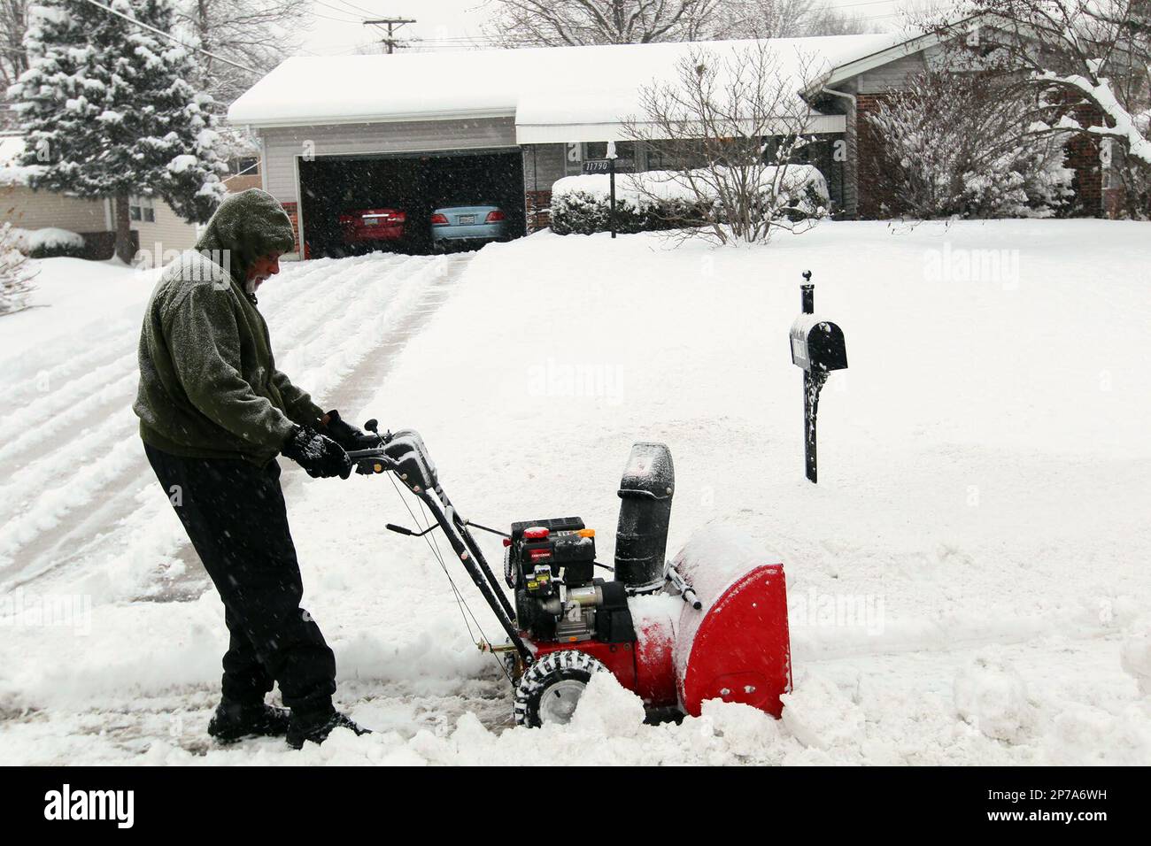 J.A. Naylor clears his sidewalk in St. Louis county, Mo., Thursday, Jan. 20, 2011. A band of bitterly cold weather spread across Missouri Thursday, forcing schools to close, causing hundreds of traffic accidents and leaving more than a foot of snow in some areas. (AP Photo/St. Louis Post-Dispatch, Emily Rasinski) EDWARDSVILLE INTELLIGENCER OUT; THE ALTON TELEGRAPH OUT Banque D'Images
