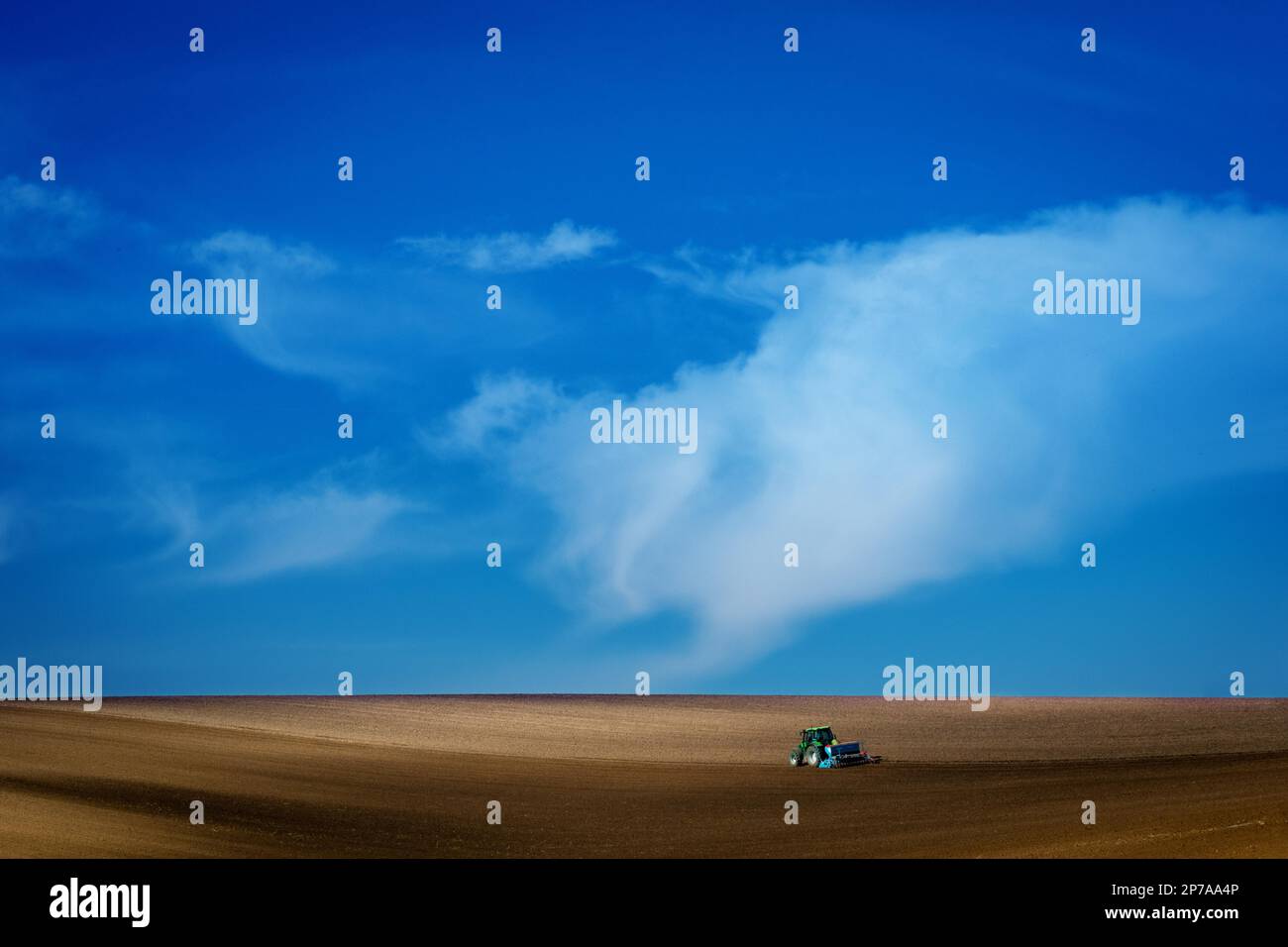 Travailler avec un tracteur agricole dans les champs moraves. Un magnifique ciel bleu. République tchèque, Moravie, République tchèque, Europe Banque D'Images