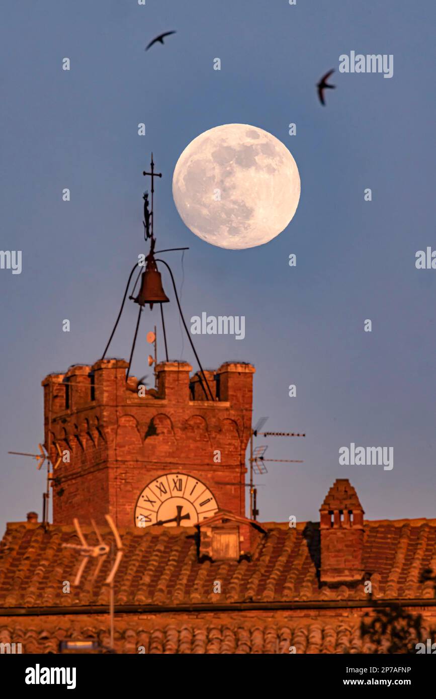 Pleine lune au-dessus de Pienza en Toscane en face de la tour historique de l'hôtel de ville avec tour d'horloge, Palazzo Pubblico, Pienza, province de Sienne, Italie Banque D'Images
