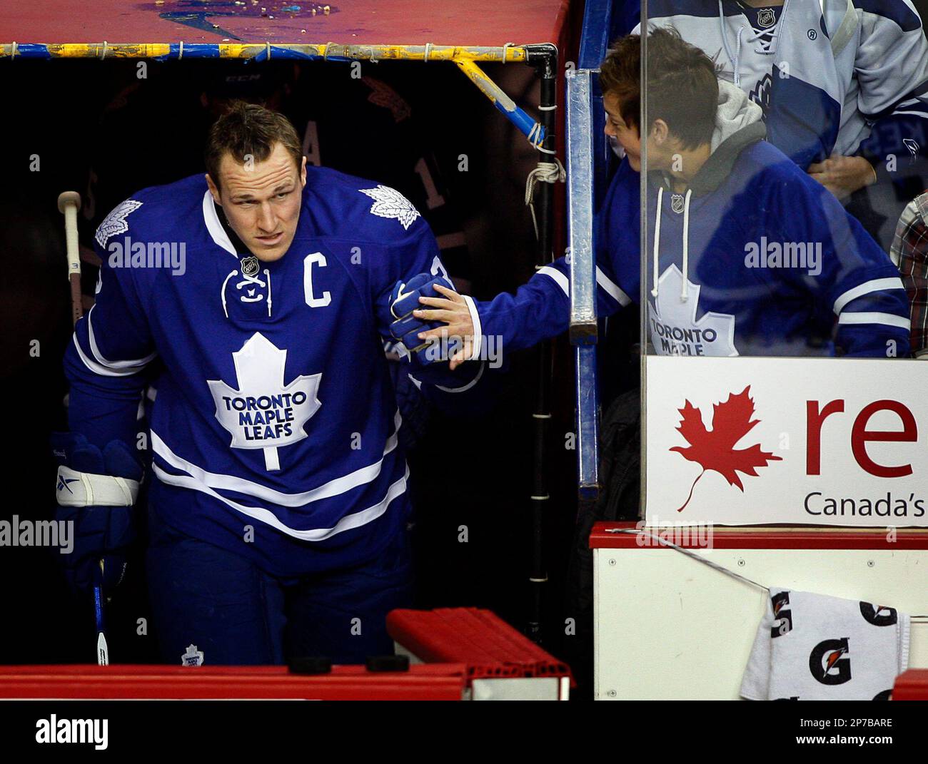 Toronto Maple Leafs' captain Dion Phaneuf, left, greets a fan as he takes to the ice during a warm-up before the start of NHL hockey game against the Calgary Flames in Calgary, Canada on Thursday, Dec. 16, 2010. The game was Phaneuf's first back in Calgary where he was originally drafted. (AP Photo/The Canadian Press,Jeff McIntosh) Banque D'Images