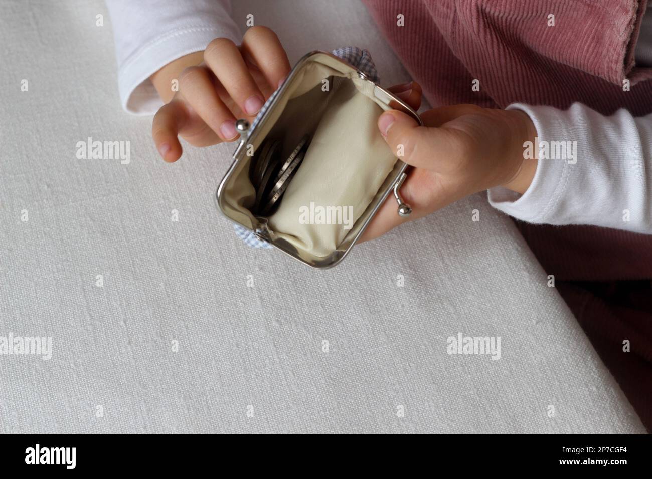 Les mains des enfants mettent des pièces de monnaie dans un portefeuille,  tout-petit avec de l'argent et la chatte dans les mains Photo Stock - Alamy