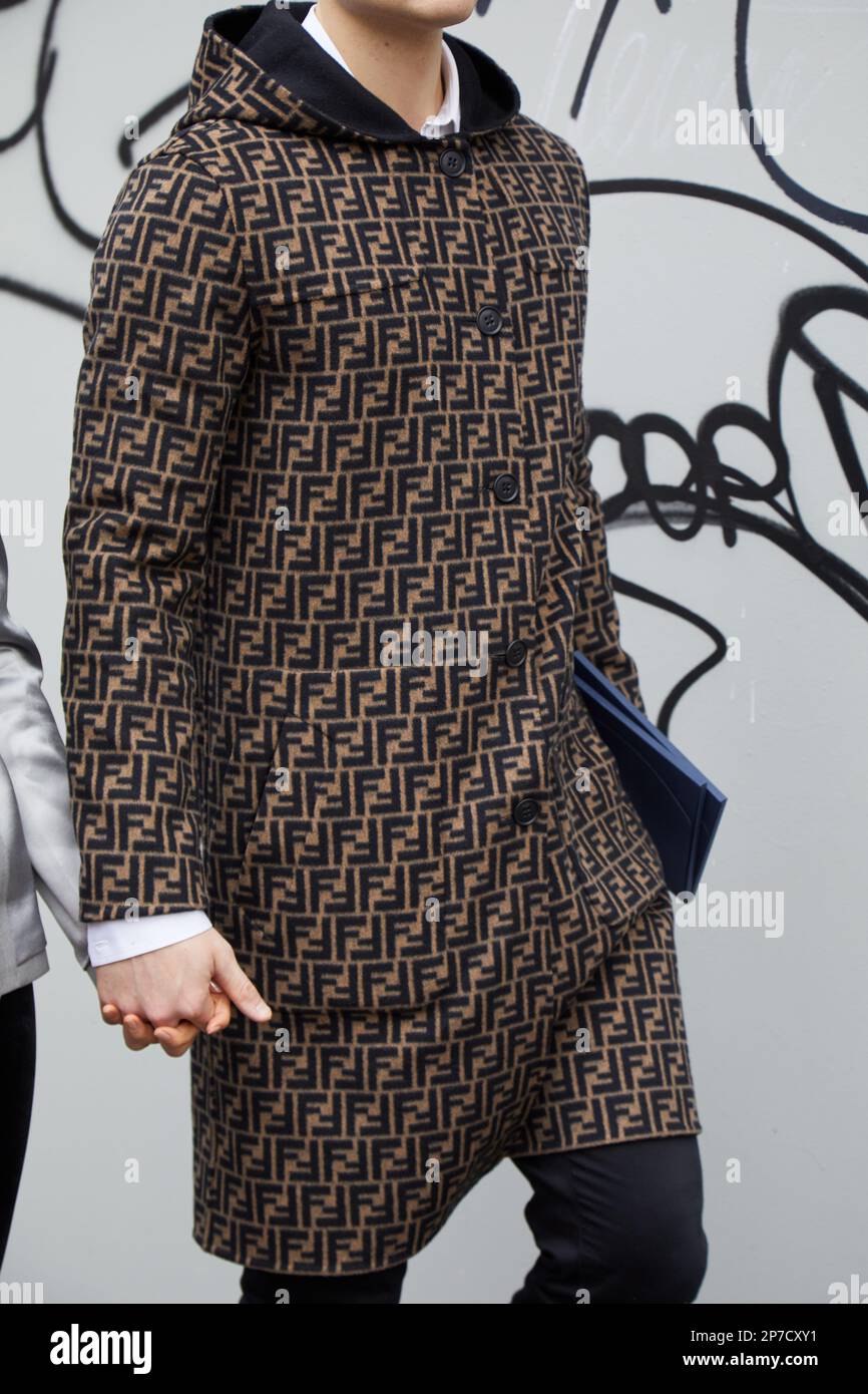 MILAN, ITALIE - 22 FÉVRIER 2023: Homme avec un manteau avec un motif brun  et noir du logo Fendi avant le spectacle de mode Fendi, Milan Fashion week  Street style Photo Stock - Alamy