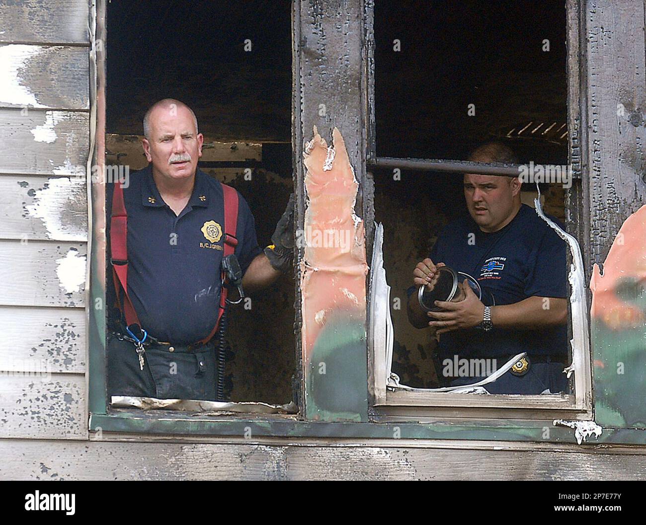 Trenton Fire Department Battalion Chief John Gribbin, left, looks out a second floor window of the Vine Street house destroyed by an overnight fire on Thursday, Aug. 26, 2010, in Trenton, N.J. Gribbin was credited with finding and rescuing a young child in the water-filled basement of the house. However, another child died in the fire. (AP Photo/The Trentonian, Gregg Slaboda) TRENTON TIMES OUT; PHILLY METRO OUT Banque D'Images