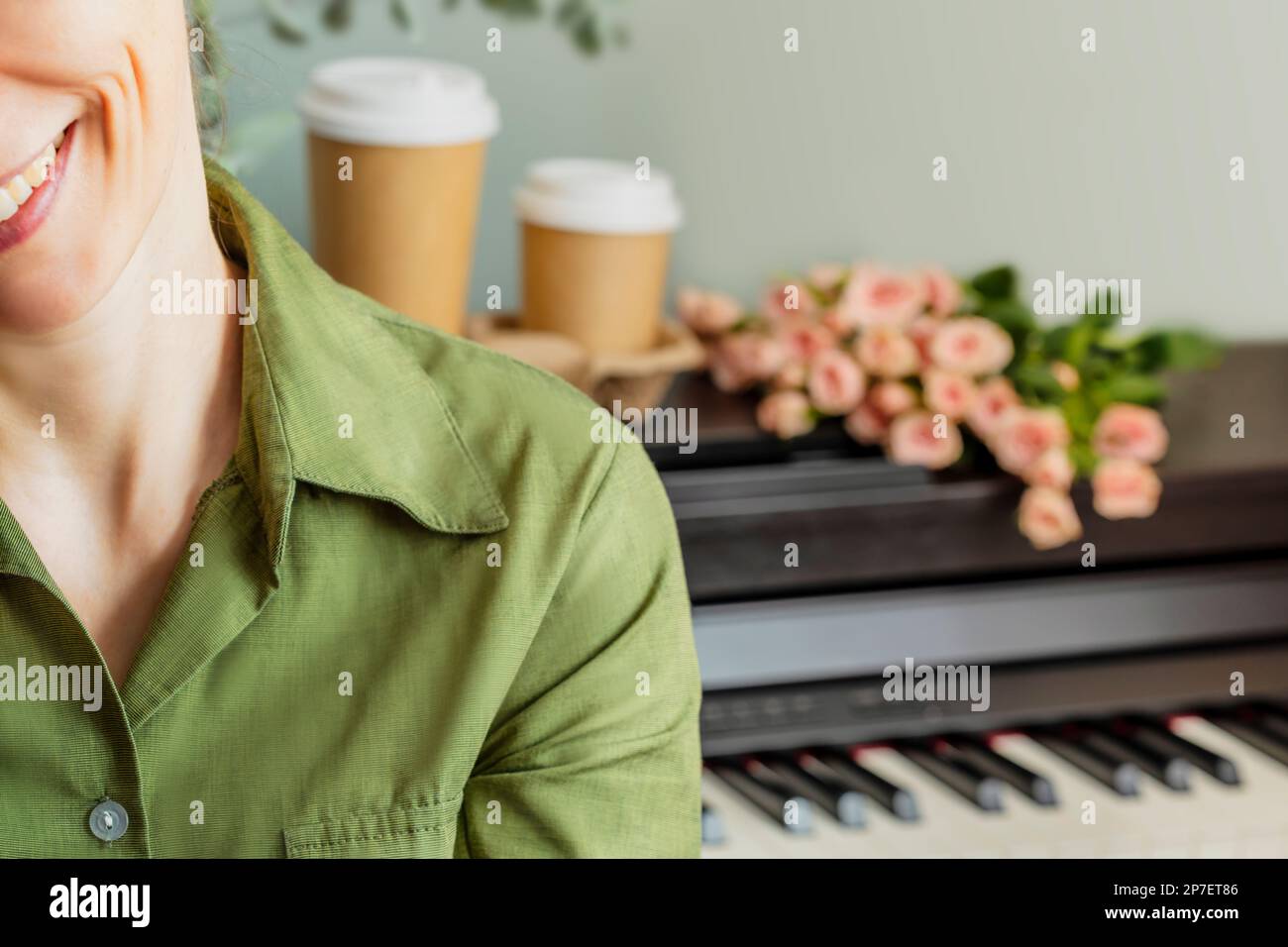 Printemps romantique composition de vacances avec femme souriante avant piano avec roses et deux tasses de café. Cours de piano, éducation musicale, passe-temps et détente Banque D'Images