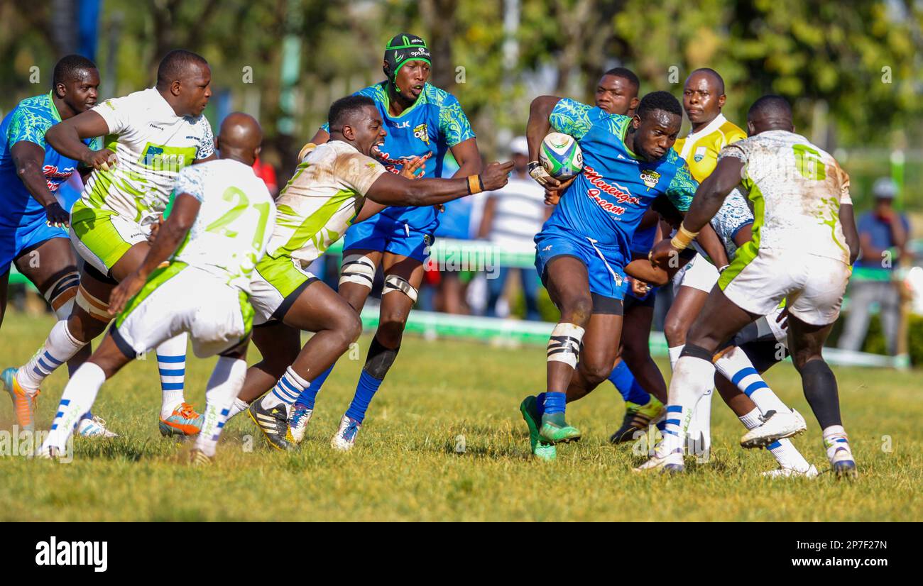 Beldad Ogeta de Menengai Oilers (bleu) et les défenseurs de la KCB lors du match de rugby en demi-finale de la coupe du Kenya entre Menengai Oilers et la KCB au KCB sports Club. Nairobi, Kenya. Banque D'Images