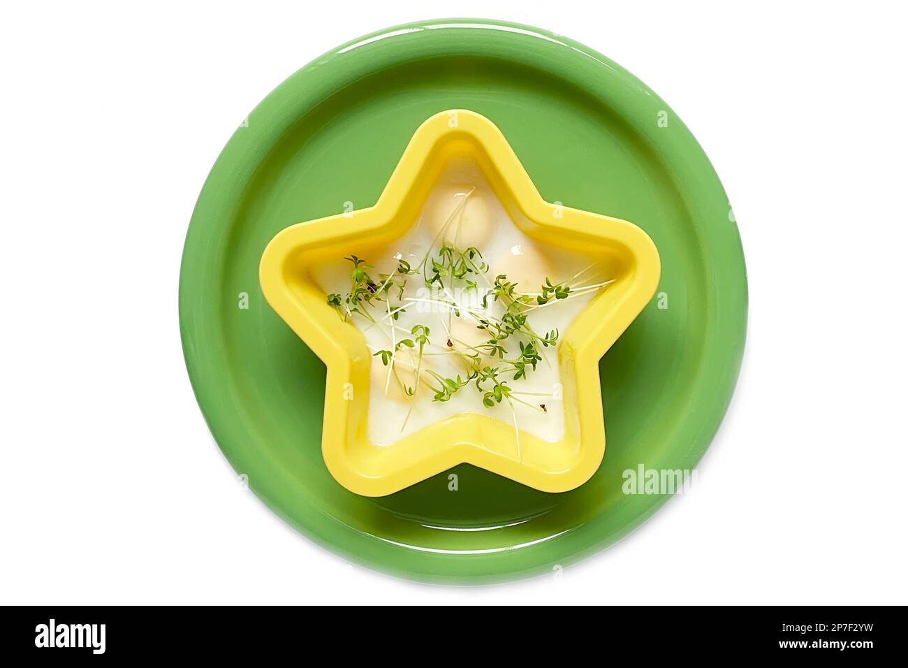 œufs de caille brouillés. les œufs dans un moule en silicone jaune reposent sur une plaque en céramique verte. salade de cresson sur une assiette Banque D'Images