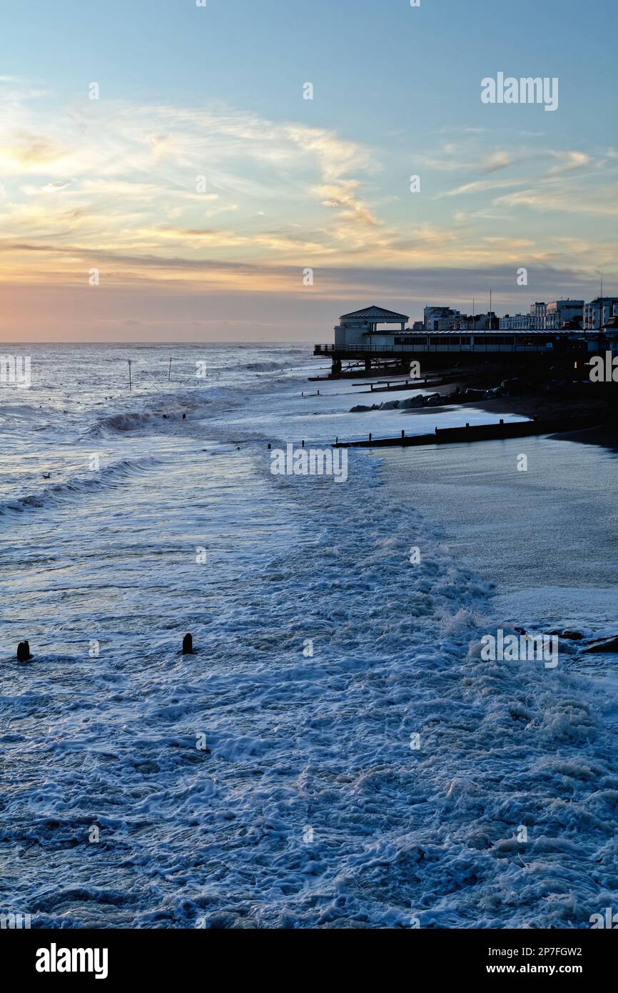 La plage de Worthing au coucher du soleil avec des vagues sur la plage, West Sussex Angleterre Royaume-Uni Banque D'Images