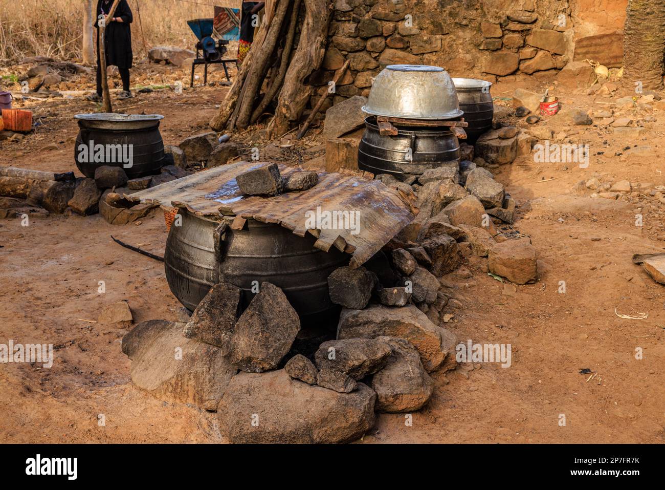 une petite brasserie de village rural fait bouillir le millet dans des pots de métal en feu ouvert pour préparer de la bière millet tchouk au togo en afrique Banque D'Images