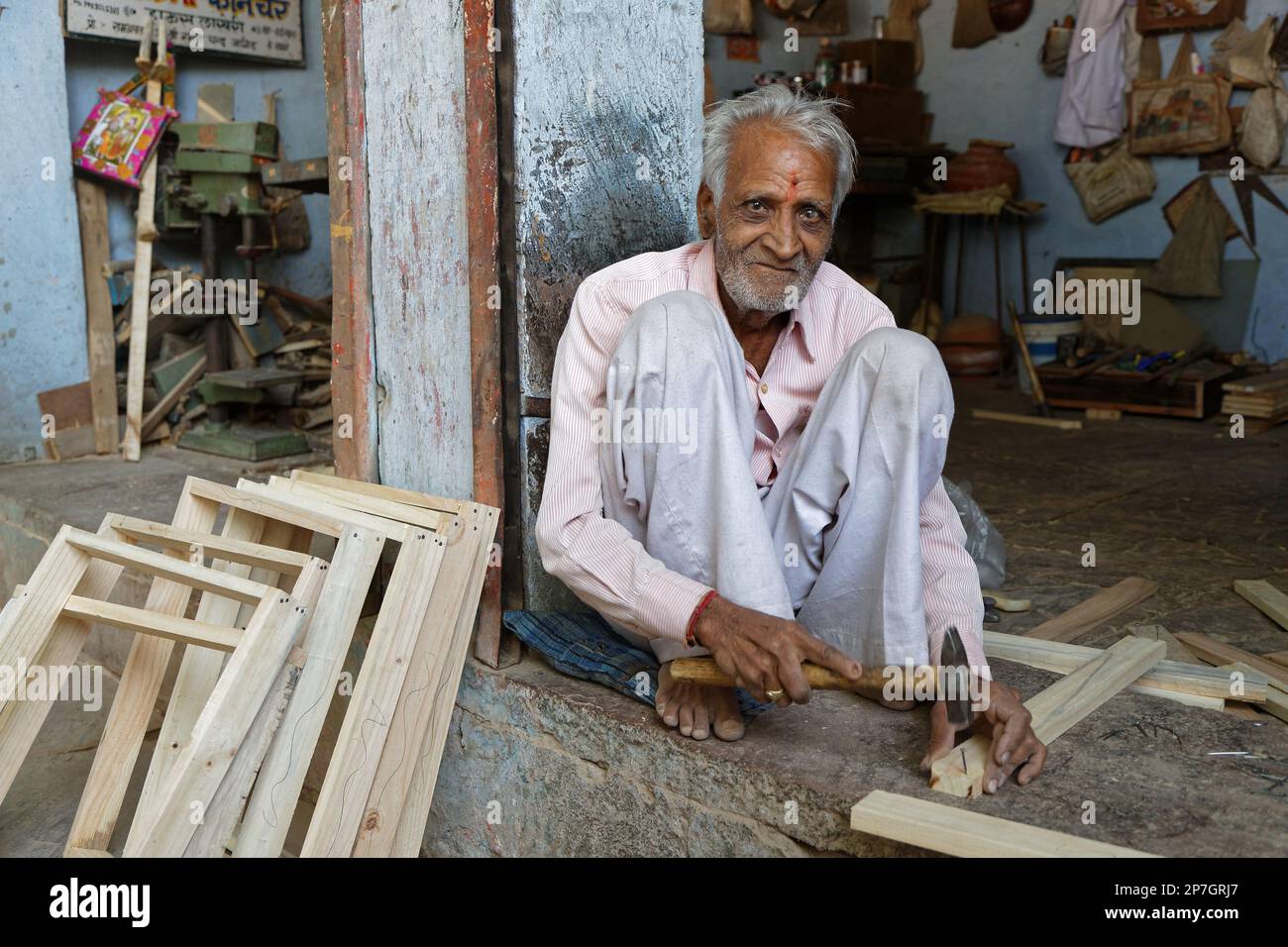 LAKHERI, INDE, 7 novembre 2017 : un vieil homme indien travaille sur des pièces de bois pour fabriquer des cadres. Banque D'Images