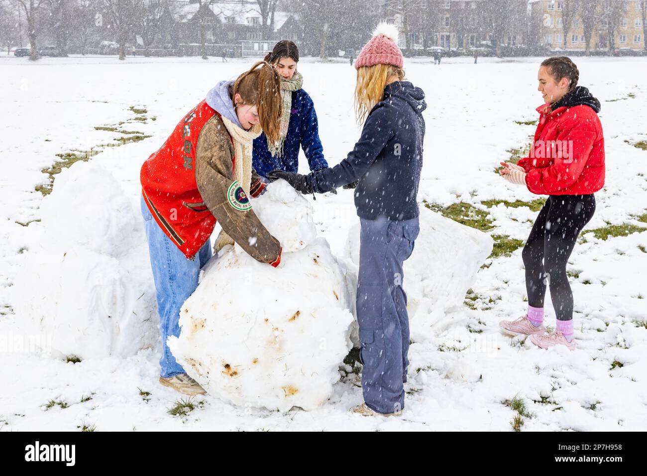 Les jeunes femmes jouent dans la neige Banque D'Images