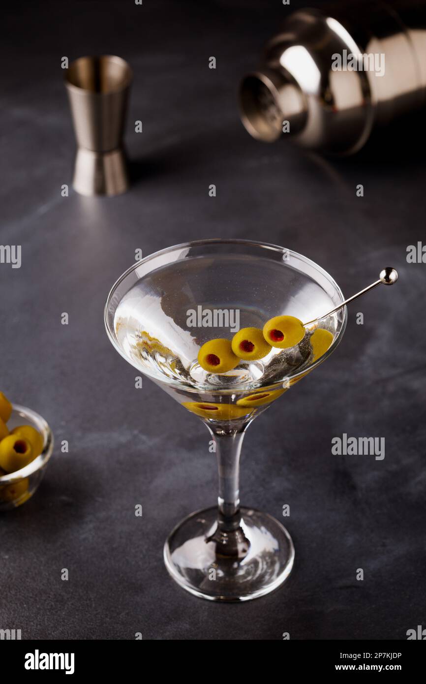 Classique Dry Martini avec olives sur table en pierre sombre. Banque D'Images