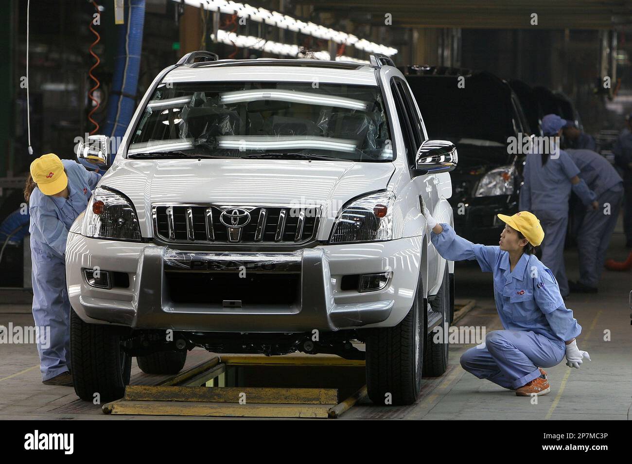 Two workers polish a Prado Suv at a plant of Sichuan Faw Toyota Motor Co, Ltd. in Chengdu of China's Sichuan province on May 12 2006. Sichuan Faw Toyota Motor Co, Ltd. established in November 1998 mainly produces Coaster cars and Prado cross-country cars. China's first-quarter car exports surpassed 62,000, a 139 percent increase over last year, at a value of $647 million, the Ministry of Commerce said.(Photo By He Dalu/Color China Photo/AP Images) Banque D'Images