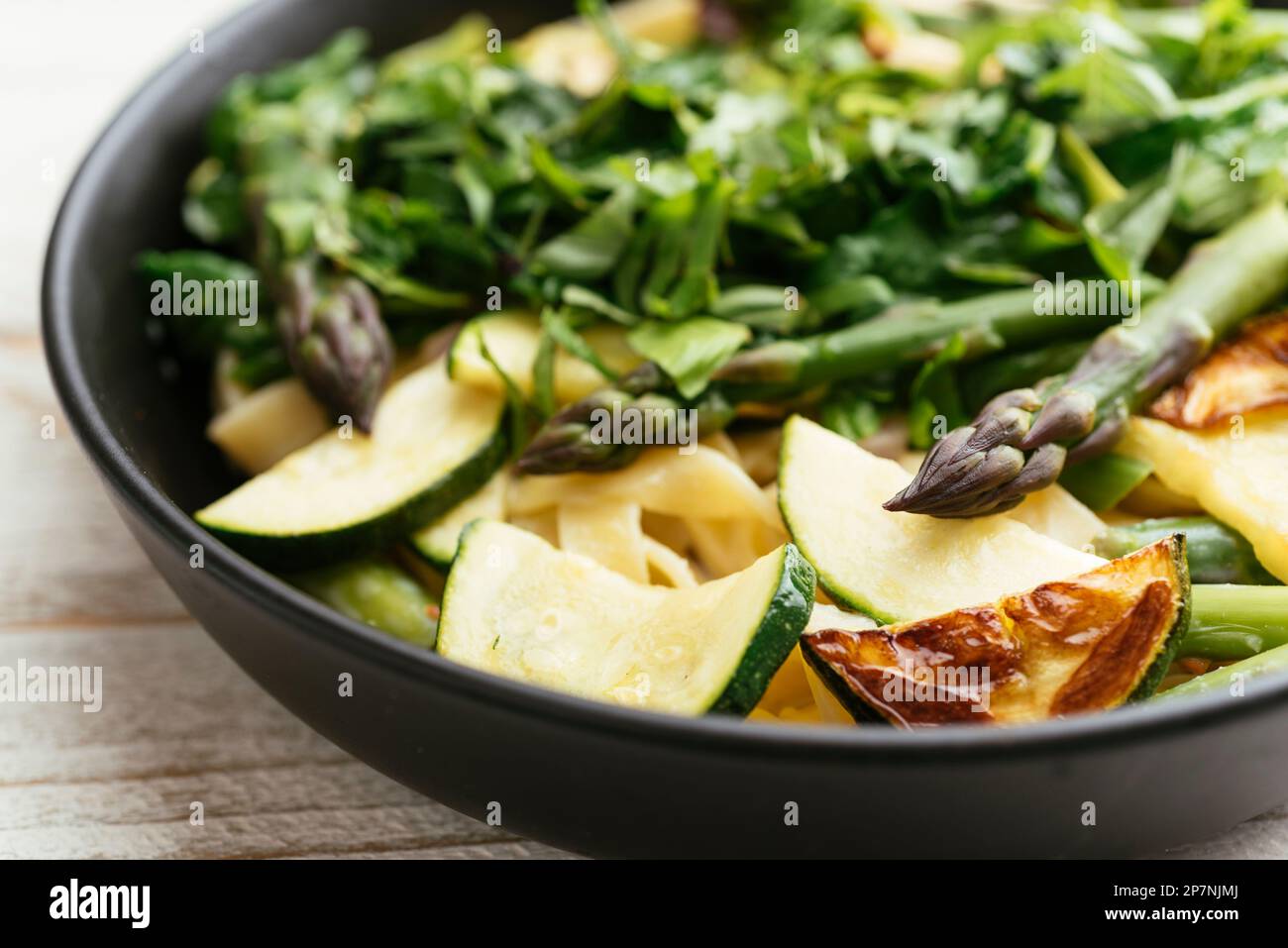 Bol avec tagliatelle maison aux asperges vertes, courgettes et épinards. Banque D'Images
