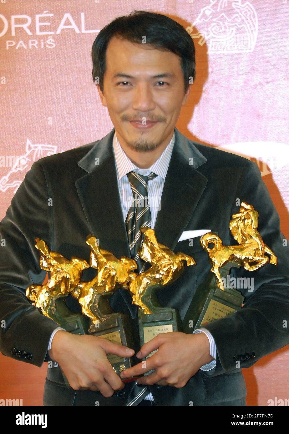 Taiwanese director Leon Dai holds his four awards include Best Director and Best Feature Film at the 46th Golden Horse Awards, Saturday, Nov. 28, 2009, in Banchiau, Taipei County, Taiwan. The Golden Horse awards are the Chinese-language film industry's biggest annual events. (AP Photo/Chiang Ying-ying) Banque D'Images