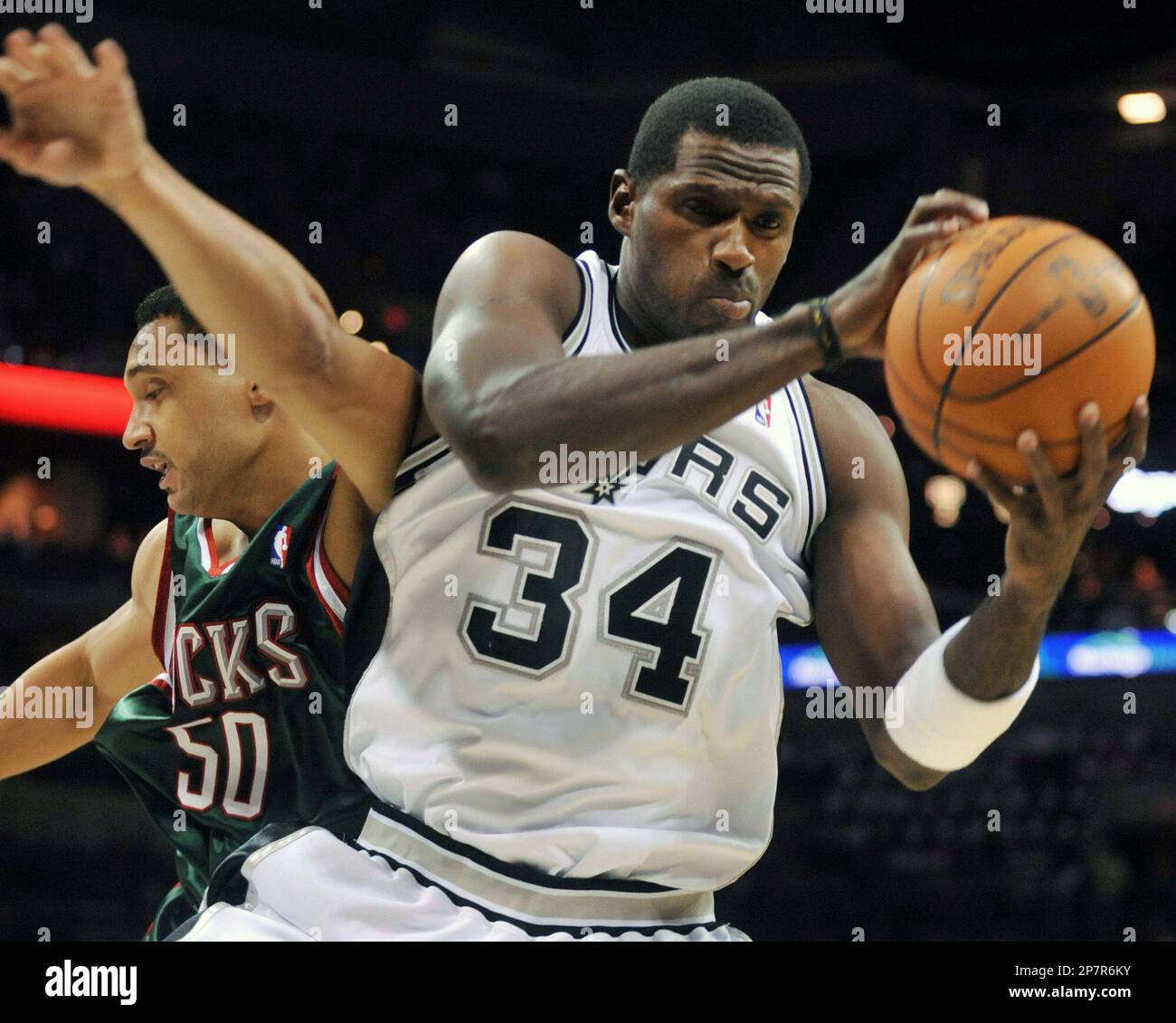 San Antonio Spurs' Antonio McDyess grabs a rebound in front of the Milwaukee Bucks' Dan Gadzuric during the first half of an NBA basketball game in San Antonio, Monday, Nov. 23, 2009. (AP Photo/Bahram Mark Sobhani) Banque D'Images