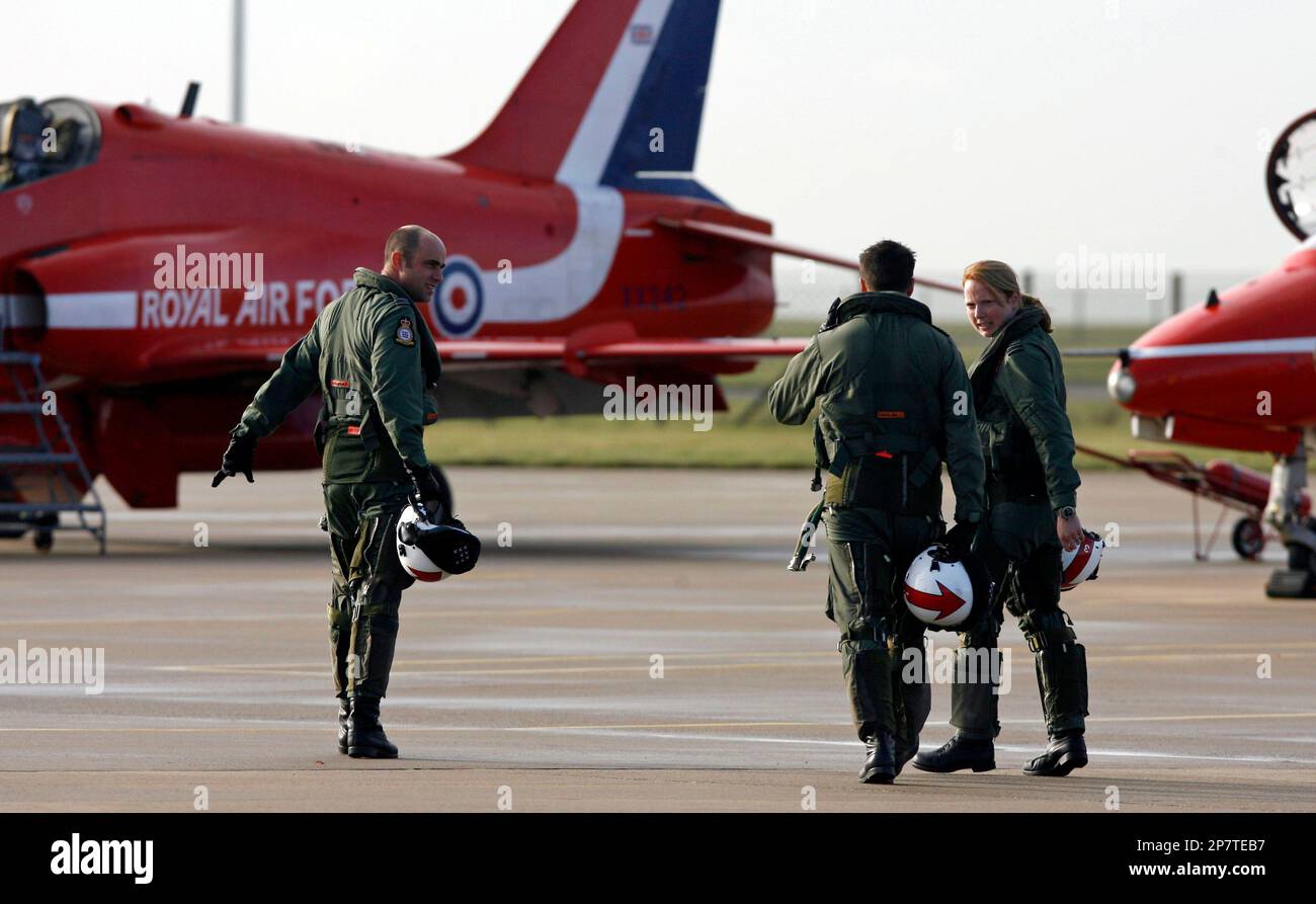 Red Arrow pilot Flight Lieutenant Moore, right, walks to a Hawk aircraft at the Royal Air Force base at Scampton, England, Thursday Nov. 12, 2009, after being named as the first female pilot to serve with the Red Arrows, the RAF's aerobatic team. Earlier in her air force career, Moore, 31, served as a Qualified Flying Instructor, teaching students to fly the advanced fast jet trainer, before flying the Tornado GR 4 on operations in Iraq. (AP Photo/Simon Dawson) Banque D'Images