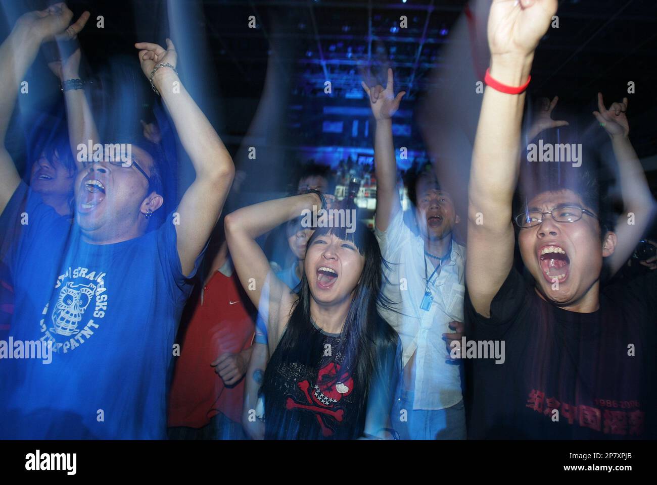 Chinese rock fans go wild during a concert directed by Chinese rock music icon Cui Jian to mark the 20th anniversary of rock music in China held at an indoor stadium in Shenyang, northern China's Liaoning province on June 17, 2006. (Color China Photo via AP Images) Banque D'Images