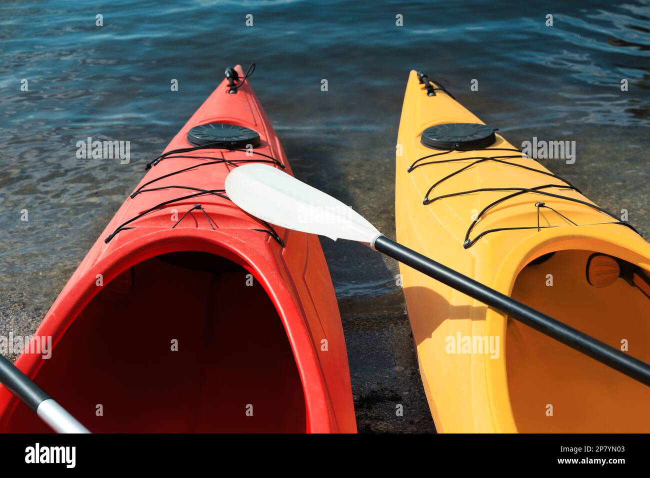 Kayaks modernes avec paddle sur la rivière, à proximité. Activité de camp d'été Banque D'Images Kayaks modernes avec paddle sur la rivière, à proximité. Activité de camp d'été Banque D'Images