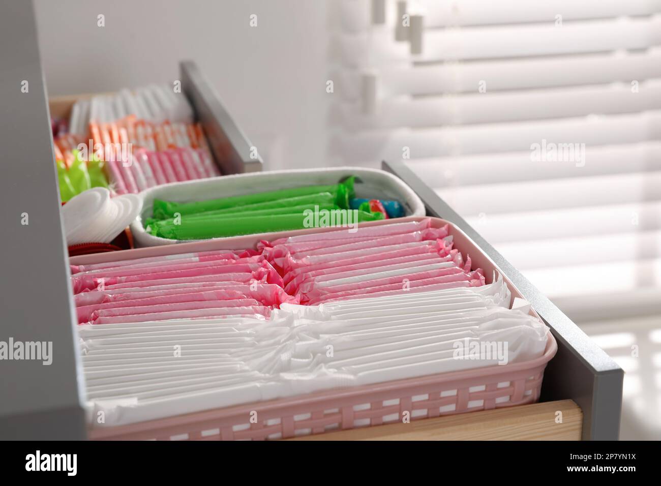 Ouvrez le tiroir de l'armoire avec les tapis menstruels, les tampons et les pantyliners à l'intérieur, en gros plan Banque D'Images