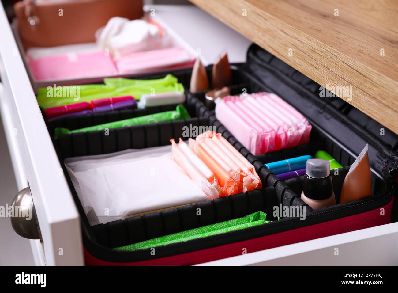 Ouvrez le tiroir de l'armoire avec les tapis menstruels, les tampons et les produits de soins de la peau, et faites une présentation Banque D'Images